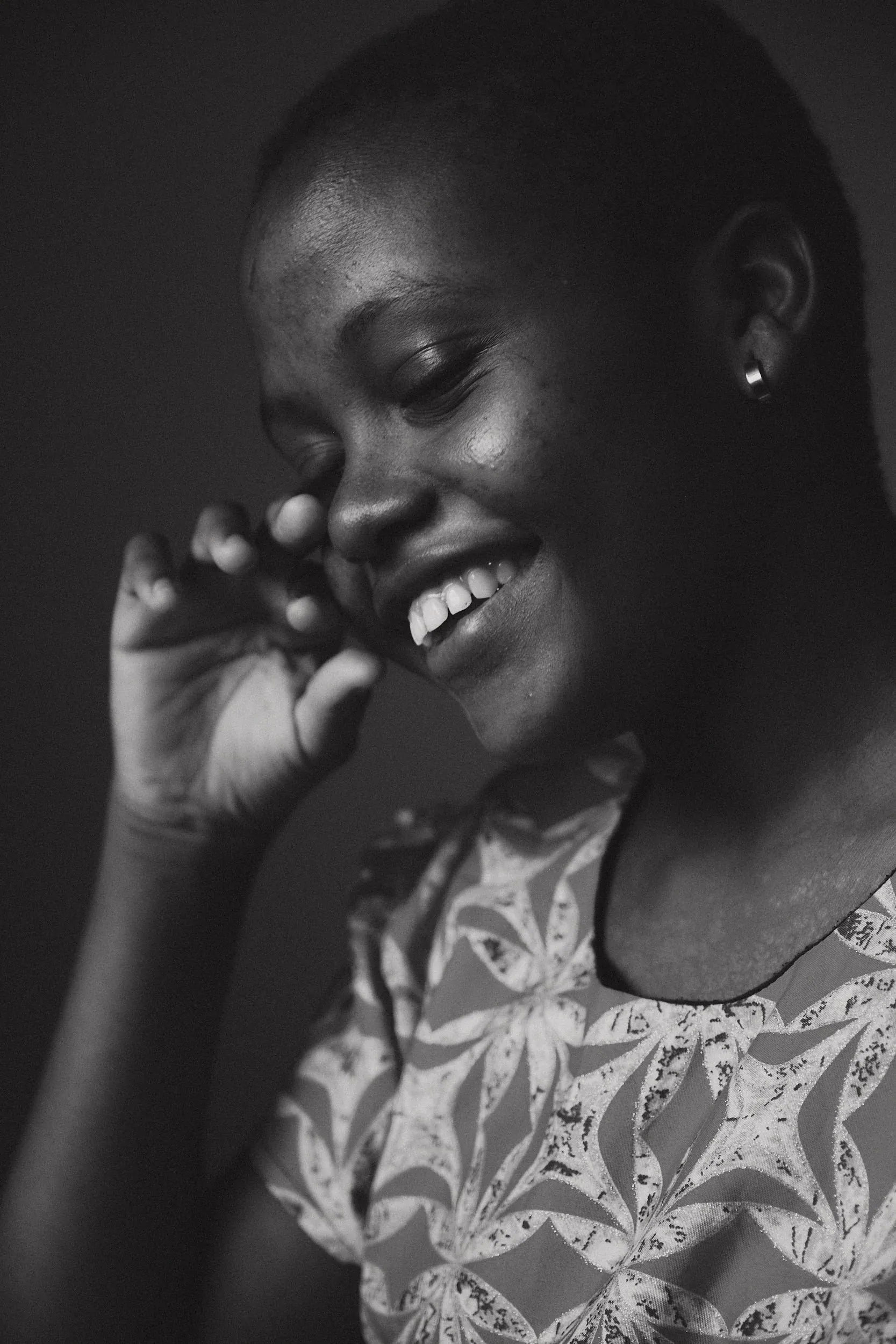 The same young woman laughing, hand to her face (black and white)