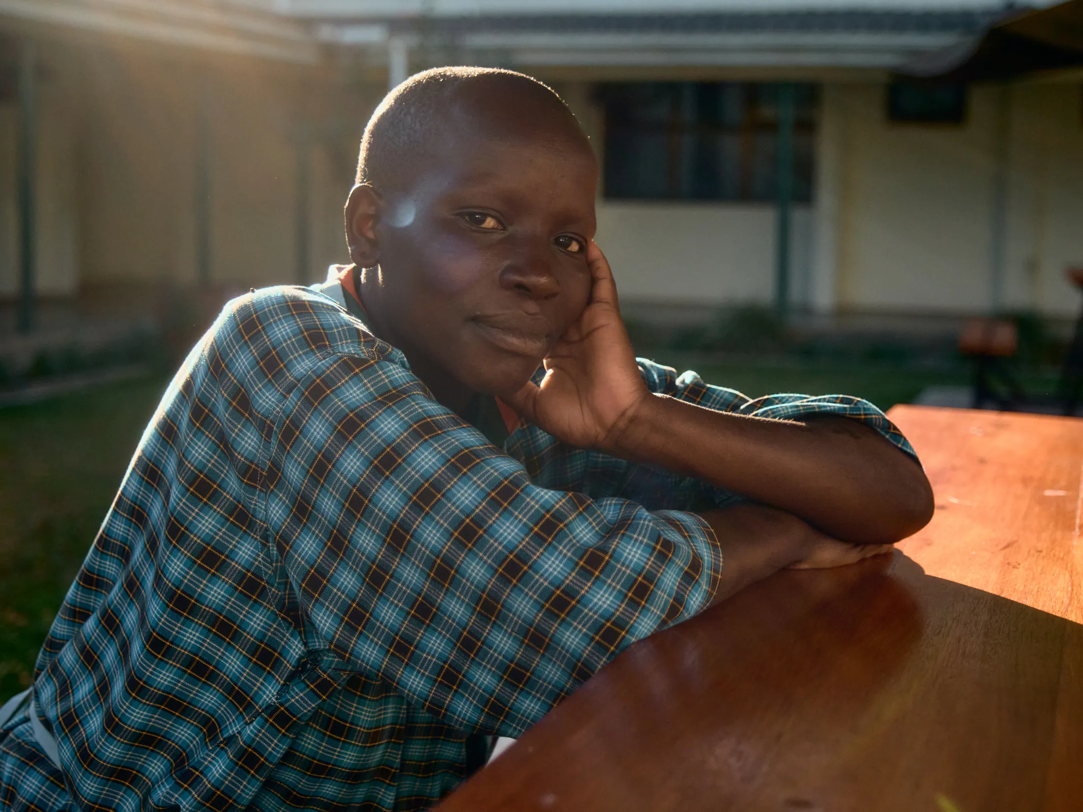 A patient leans on a table in the late afternoon light