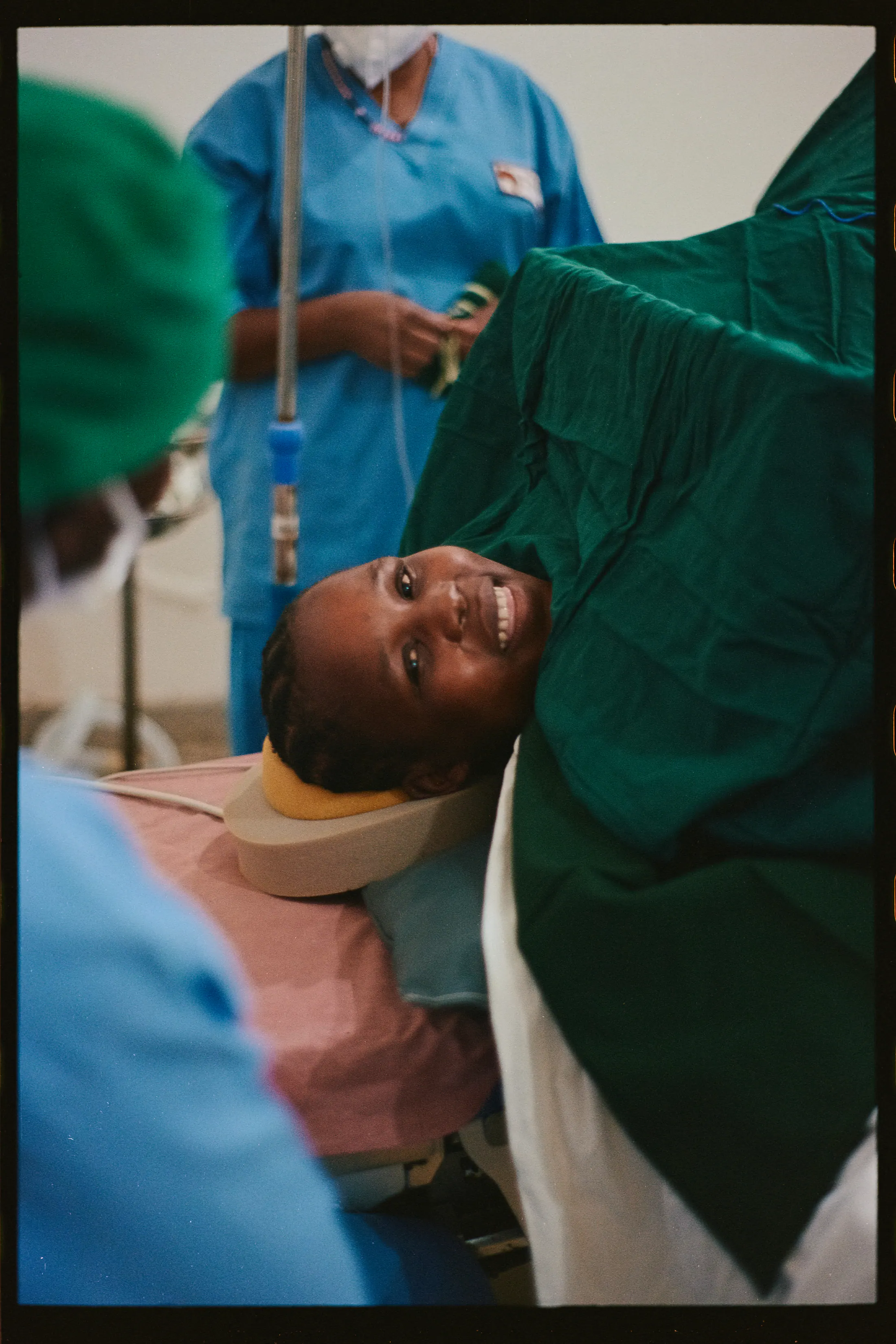 A mother smiles up from the operating table (35mm film)