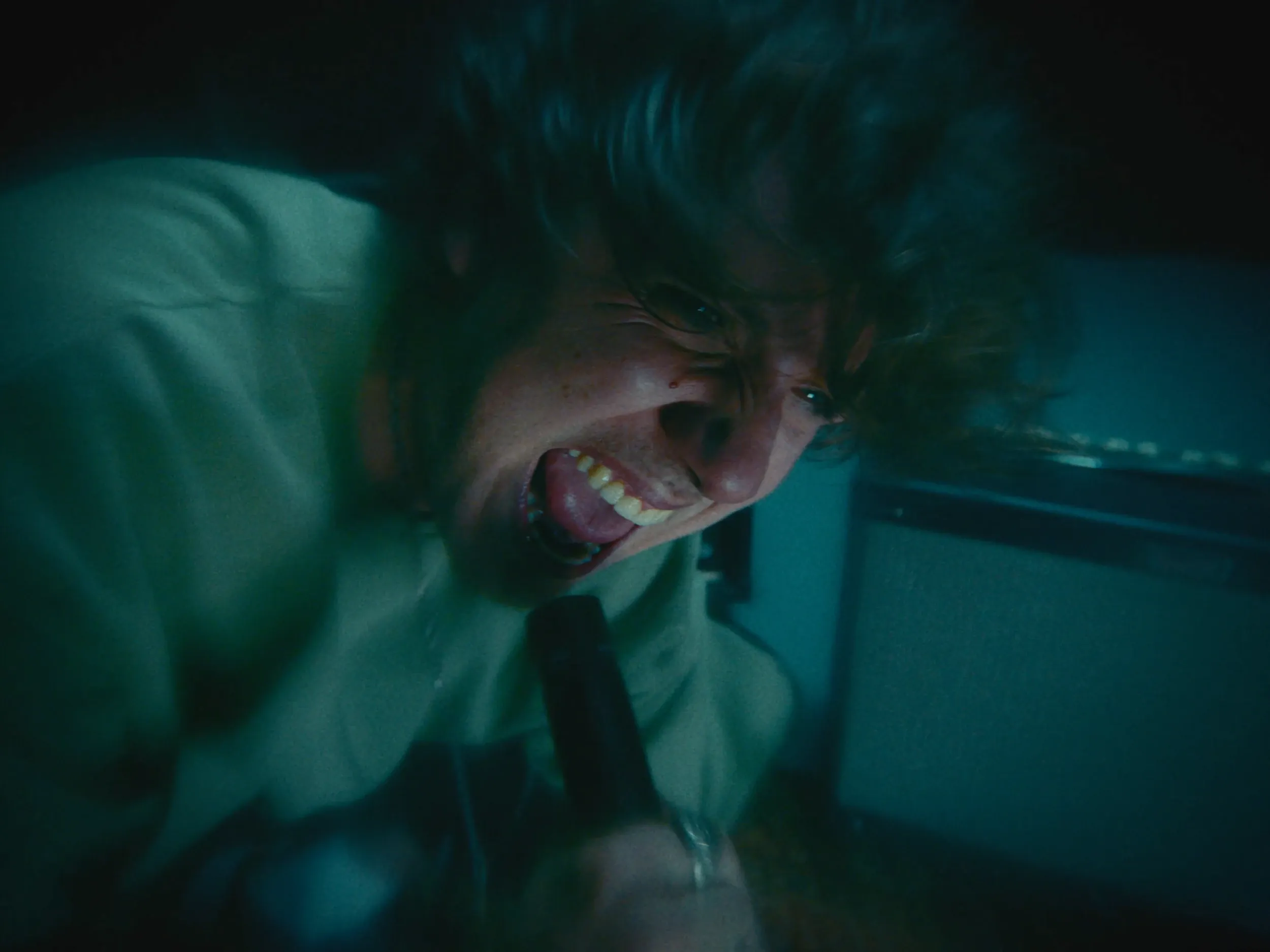 The singer screams into the mic close to the lens