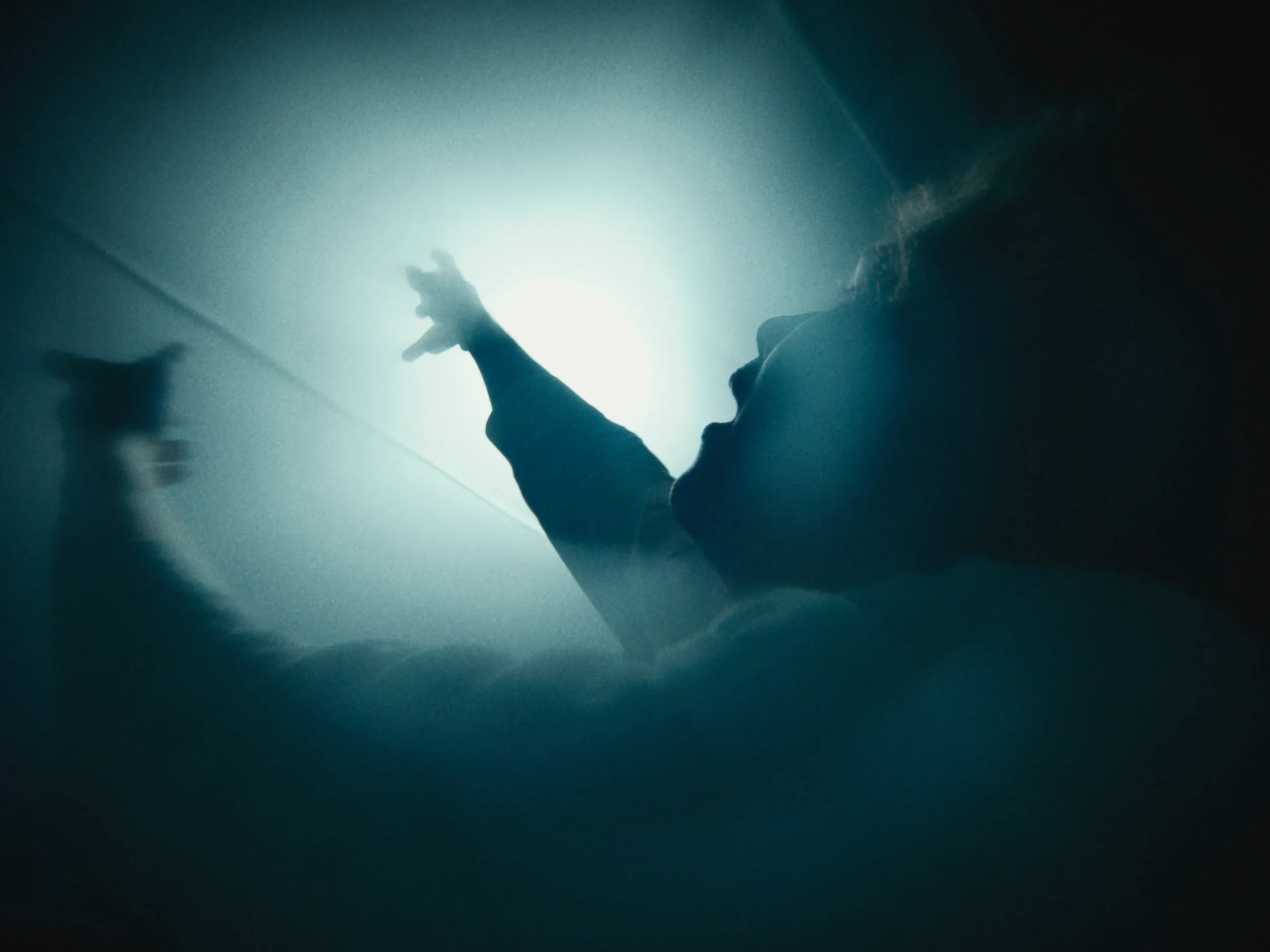 A hand reaches into a burst of white light