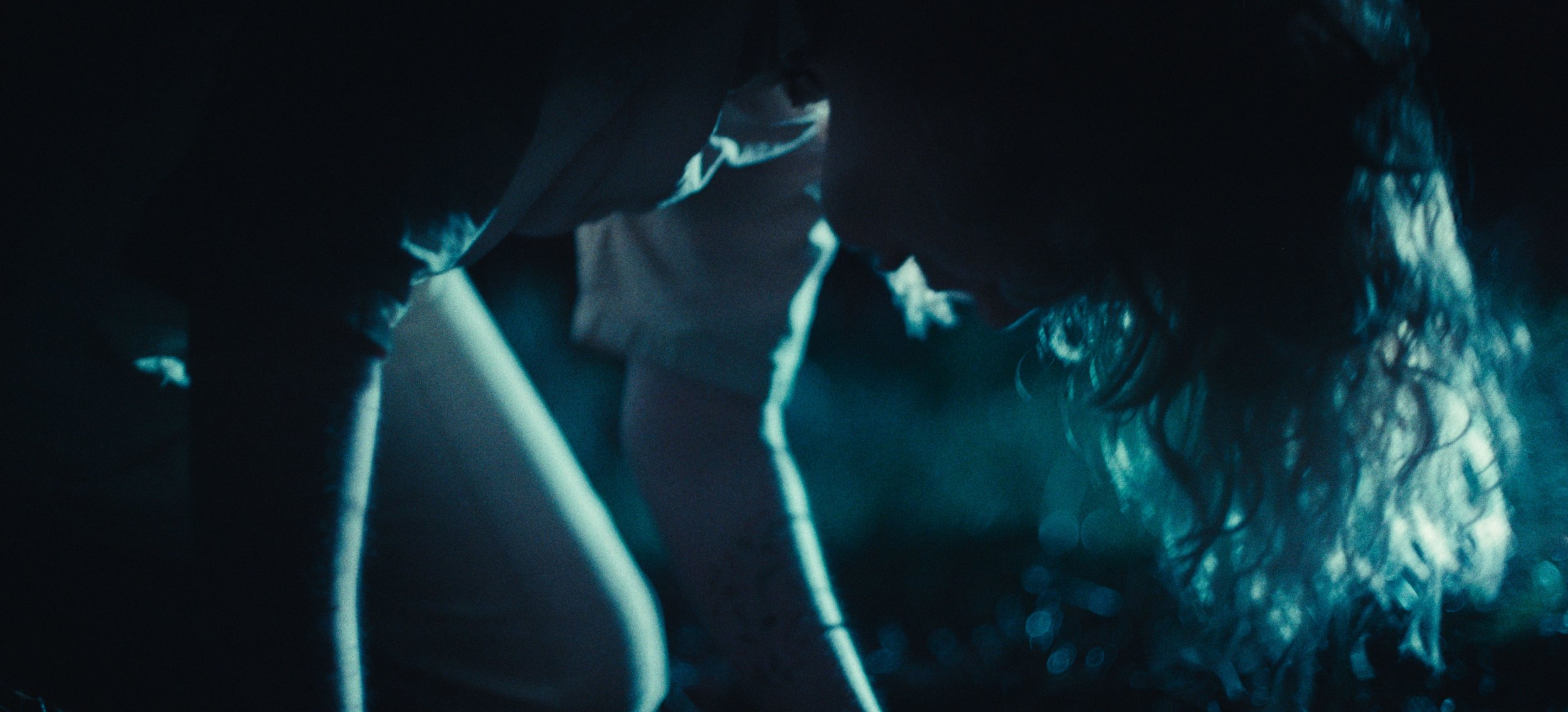 A figure in pale clothes caught in streaks of blue light