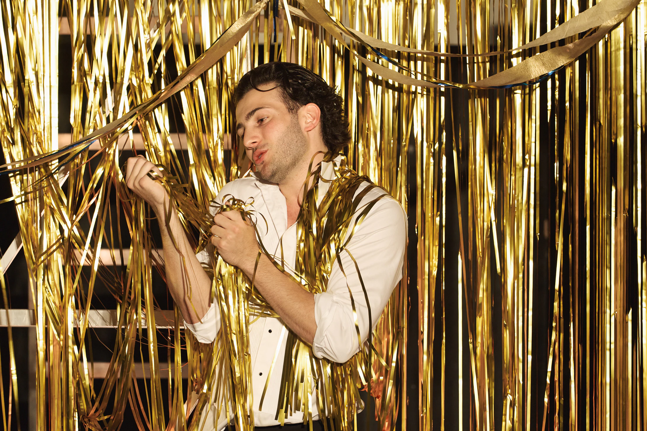 A singer tangled in gold tinsel streamers