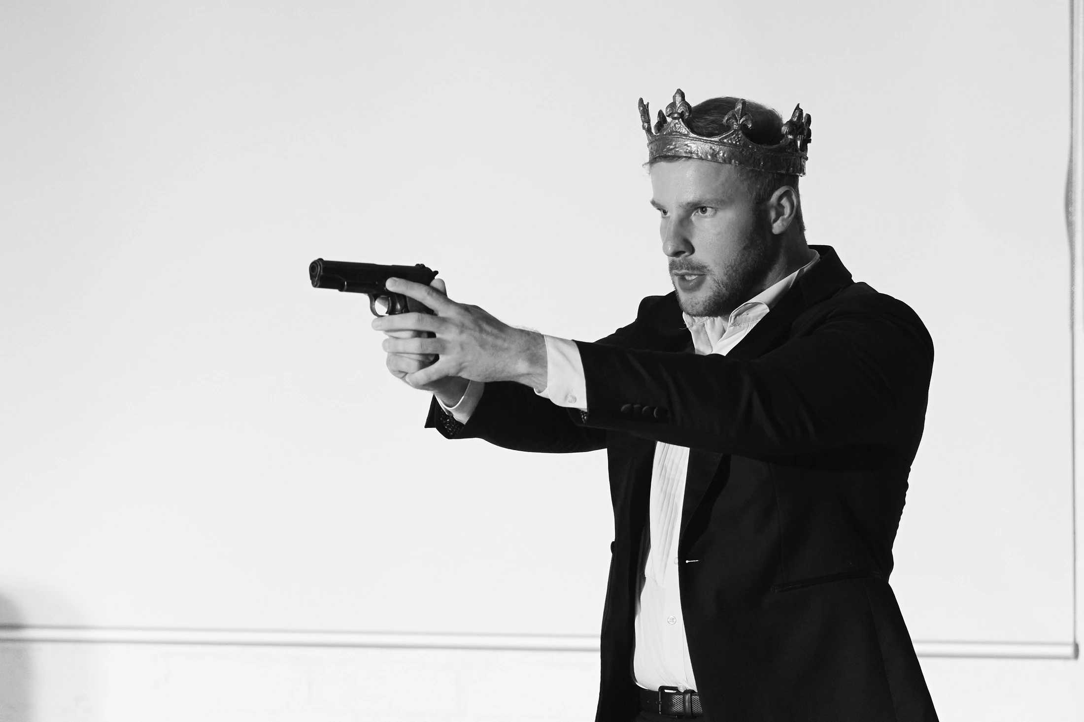 Black and white: a crowned singer aims a pistol