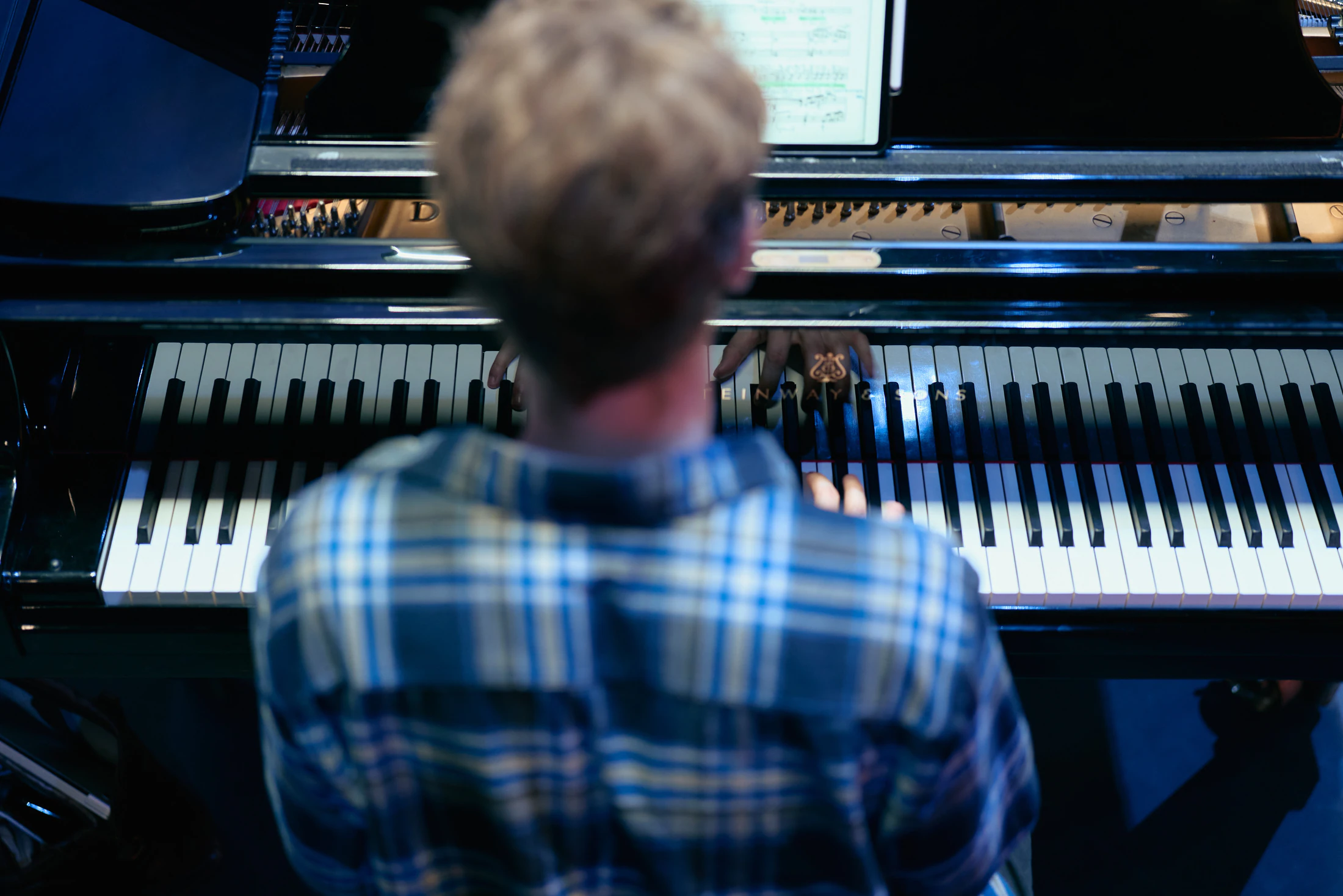 A répétiteur at the piano, seen over his shoulder