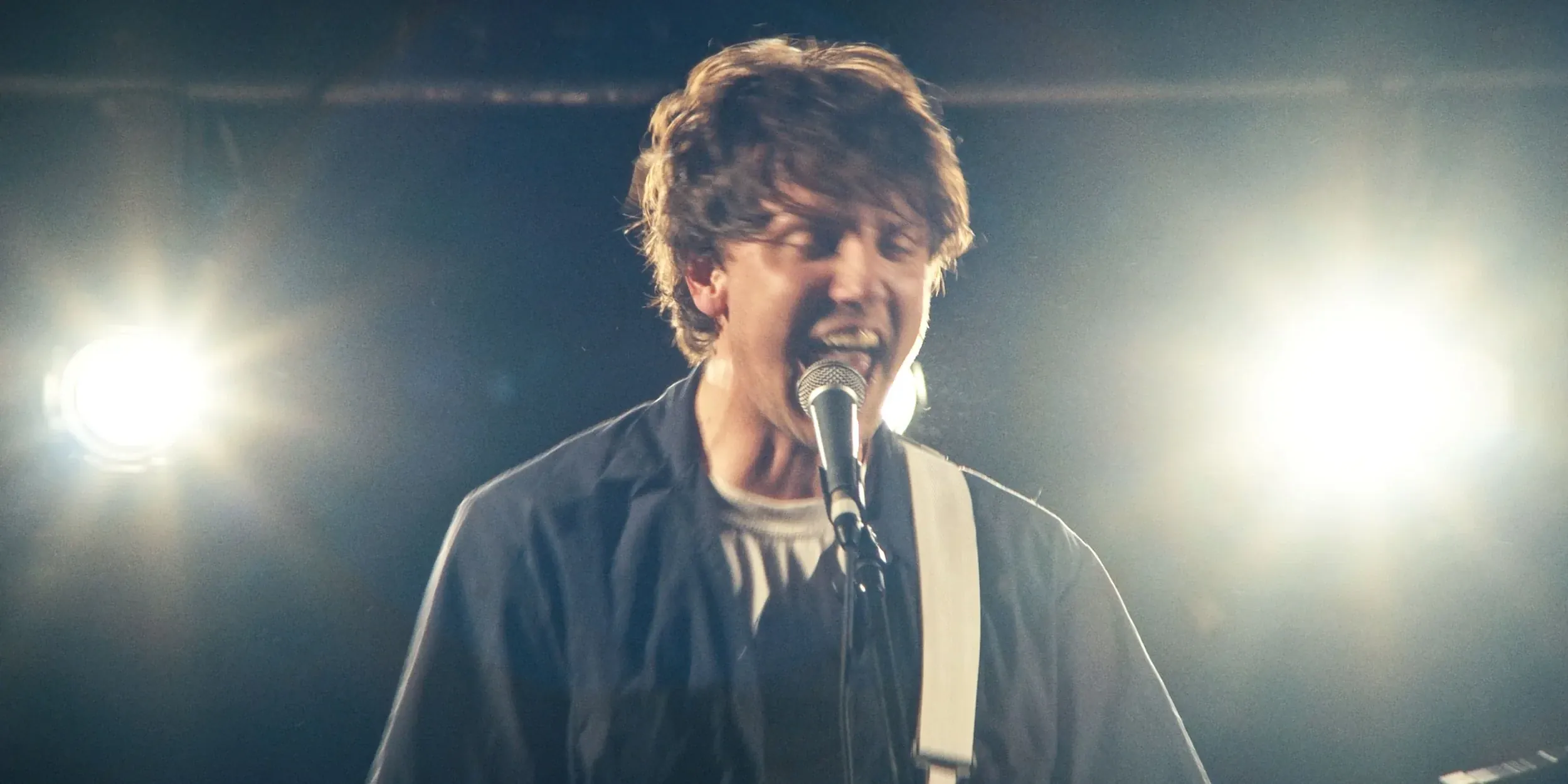 The singer at the microphone, lit from behind